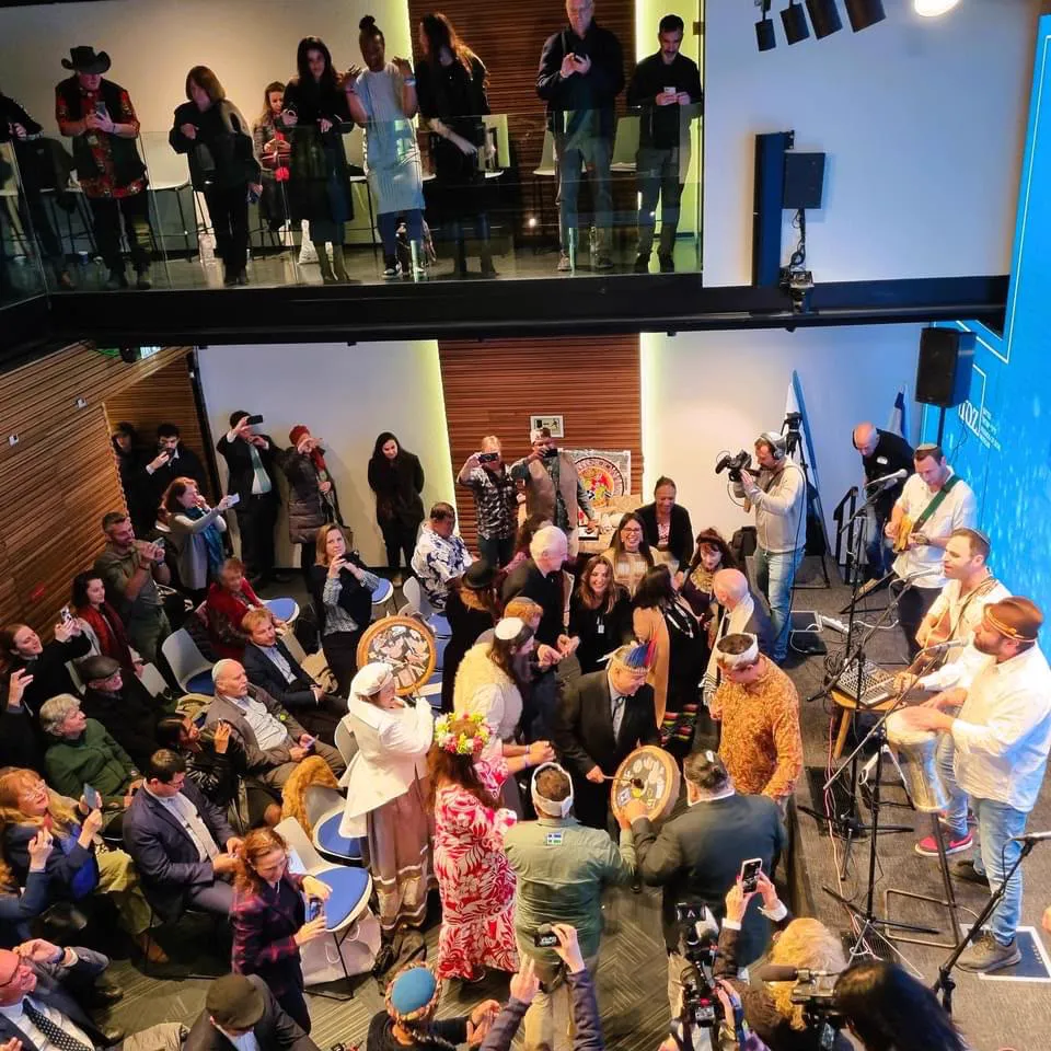 A gathering viewed from above with musicians performing beside the audience