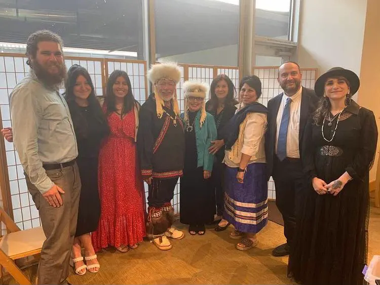 A group of people in traditional and formal clothing posing together indoors